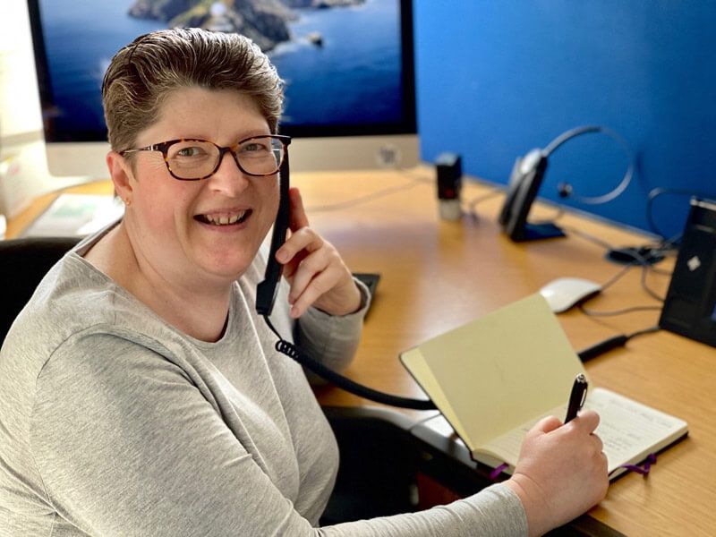 A Cotswold Drainage receptionist smiling on the phone