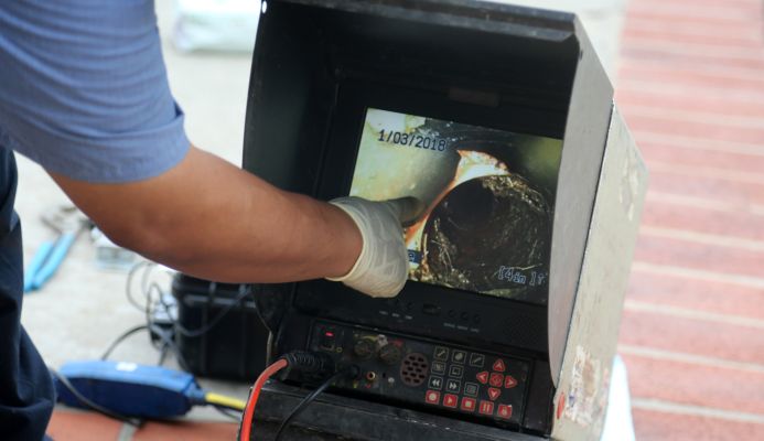 A drainage engineer using CCTV to conduct a drain survey