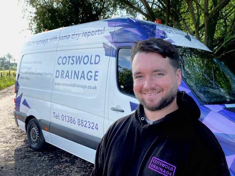 A Cotswold Drainage engineer stood infront of a Cotswold Drainage van