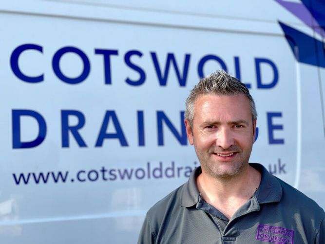 A Cotswold Drainage engineer standing infront of a Cotswold Drainage van