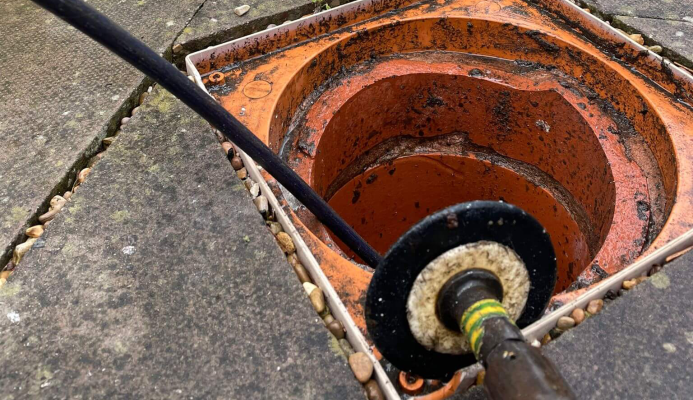 Close up of a drain being unblocked outside